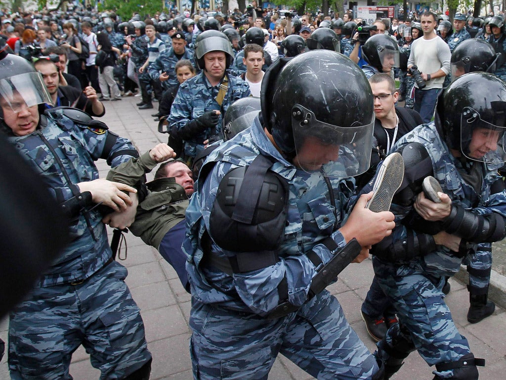 Riot police detain a protester in Moscow yesterday